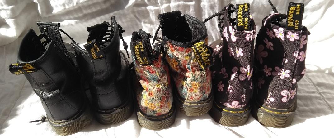 Three pairs of Doc Martin boots - one black and two flowery.