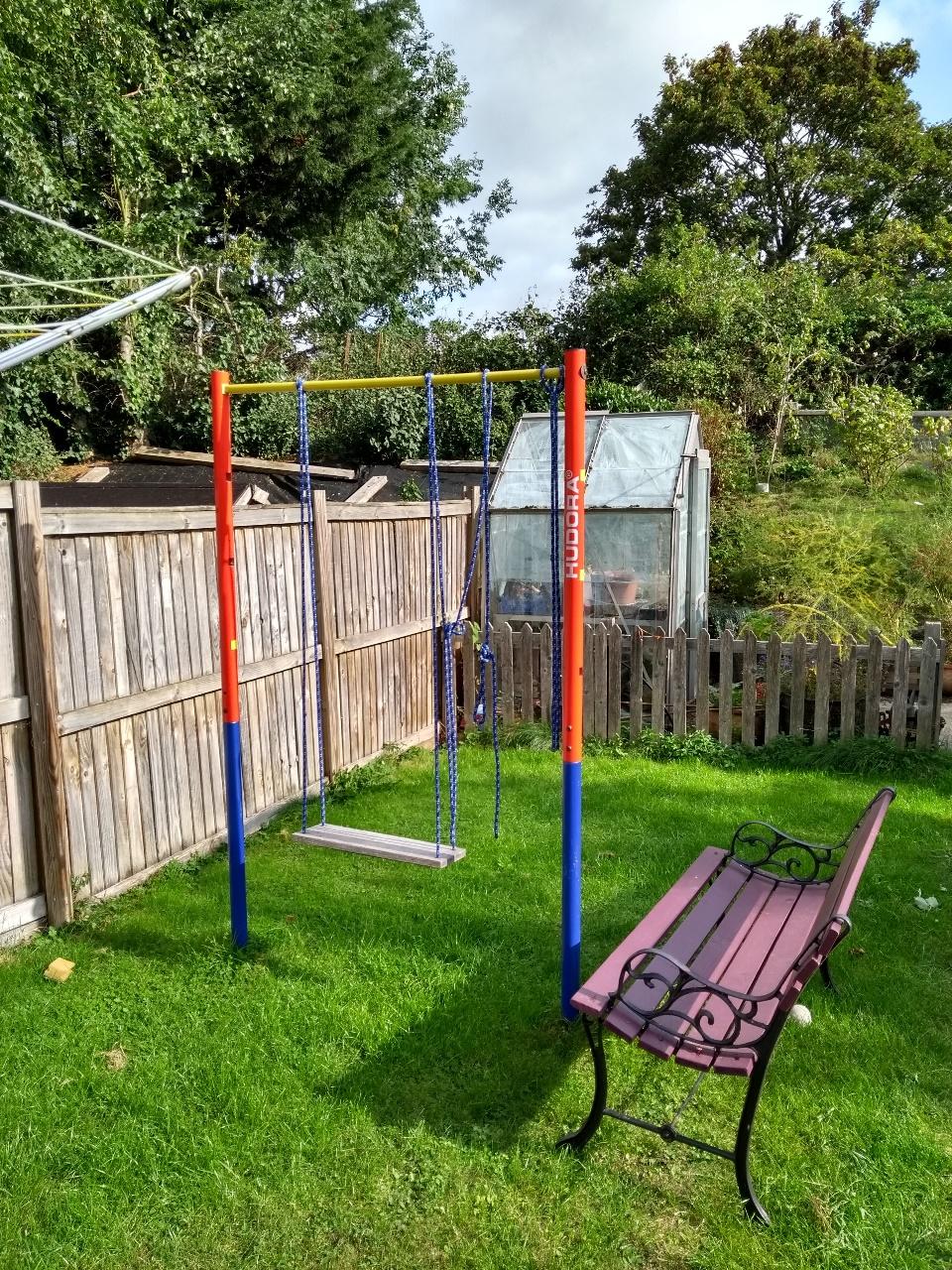A gym bar / pull up bar outdoors, in the middle of a lawn.