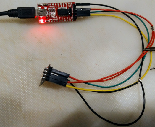 Red FTDI programming board (top) connected to ESP (bottom) for programming.  There are several wires connecting the two boards.