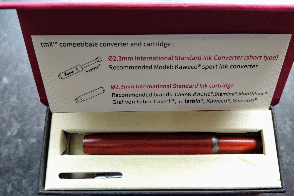 Photo of inside the box, showing a small information leaflet, the pen and something (the cartridge) showing on under the tray.