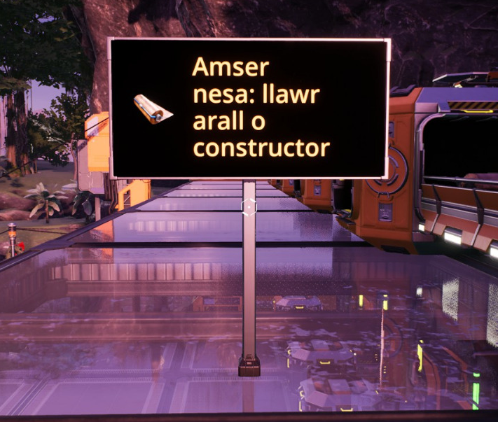 Screenshot from Satisfactory.  A notice board with orange text on a black background.  The text says "Amser nesa: llawer arall o constructor" - "next time: another floor of constructors".