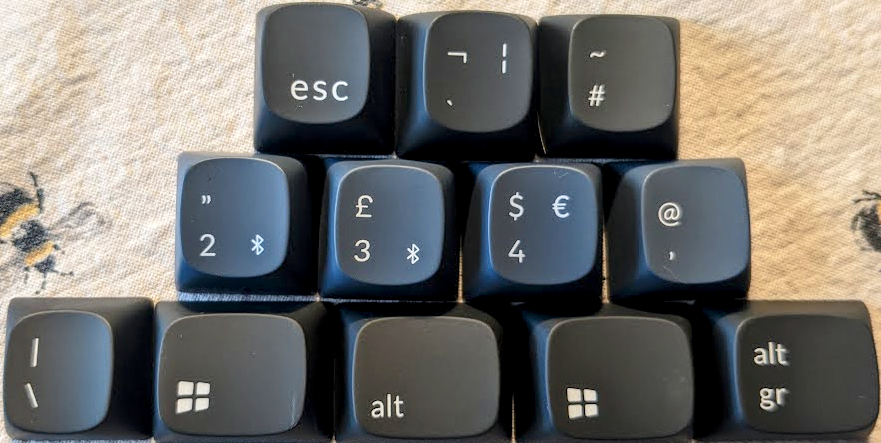 Photograph showing three rows of keys (three, four, five).  The top and bottom rows are a mid grey, with a grey / blue colour for the middle row.